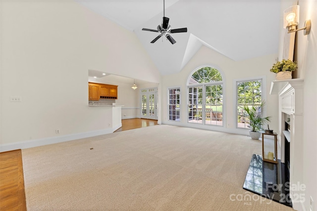 2241 Flagstick Dr, Matthews, NC 28104 - unfurnished living room with light colored carpet, a fireplace, a ceiling fan, and high vaulted ceiling