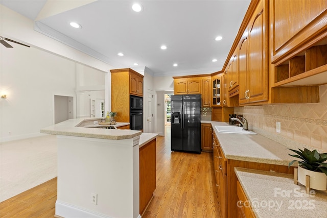 2241 Flagstick Dr, Matthews, NC 28104 - kitchen featuring black appliances, brown cabinets, light wood-style floors, recessed lighting, and backsplash