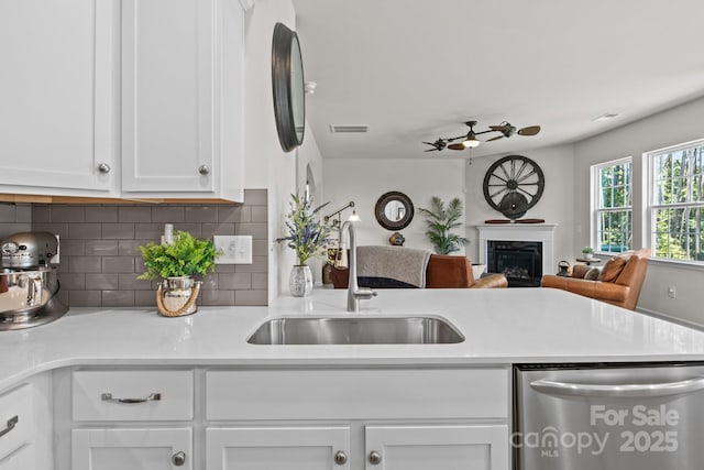 169 Rooster Tail Ln, Troutman, NC 28166 - kitchen featuring dishwasher, a ceiling fan, open floor plan, tasteful backsplash, and white cabinetry
