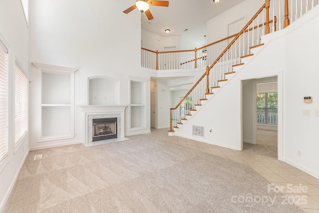 14333 Maclauren Ln, Huntersville, NC 28078 - unfurnished living room featuring tile patterned flooring, a high ceiling, stairs, a ceiling fan, and carpet flooring
