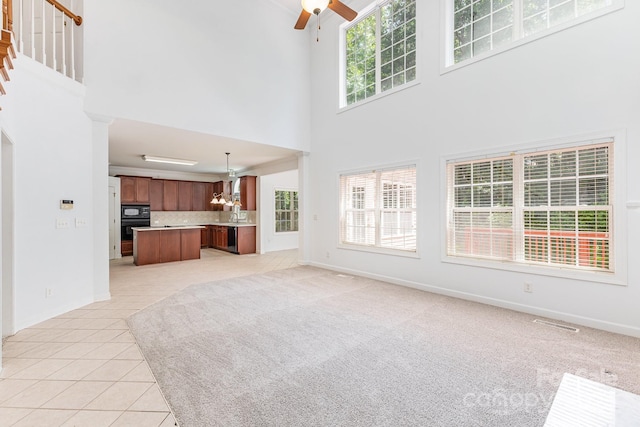 14333 Maclauren Ln, Huntersville, NC 28078 - unfurnished living room featuring a high ceiling, a chandelier, ceiling fan, healthy amount of natural light, and light tile patterned flooring
