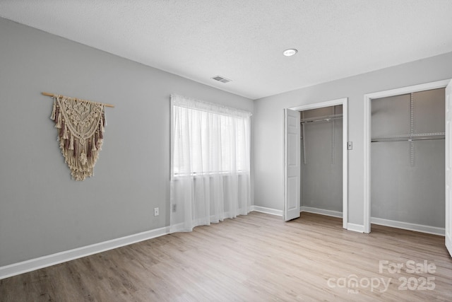 5192 Corbin Ln, Hickory, NC 28601 - unfurnished bedroom featuring multiple closets, wood finished floors, and a textured ceiling