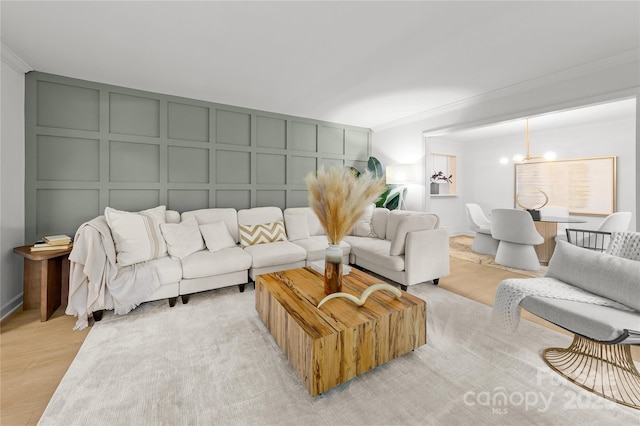 3519 Campbell Dr, Charlotte, NC 28205 - living area featuring a decorative wall, crown molding, a chandelier, and light wood finished floors