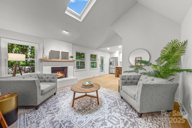 3519 Campbell Dr, Charlotte, NC 28205 - living room featuring light wood finished floors, a warm lit fireplace, high vaulted ceiling, recessed lighting, and a skylight
