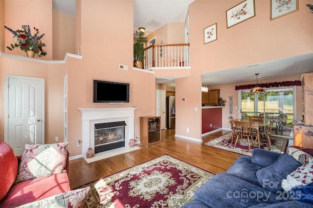 220 Holmes Ct, Concord, NC 28027 - living area featuring a towering ceiling, wood finished floors, and a fireplace with flush hearth