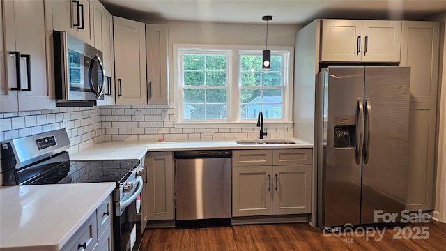 703 Central Dr NW, Concord, NC 28027 - kitchen featuring appliances with stainless steel finishes, dark wood-type flooring, decorative backsplash, pendant lighting, and light countertops