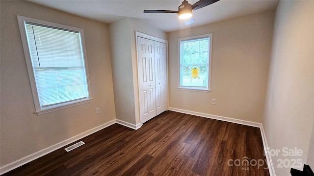 703 Central Dr NW, Concord, NC 28027 - unfurnished bedroom featuring dark wood-style floors, a closet, and a ceiling fan
