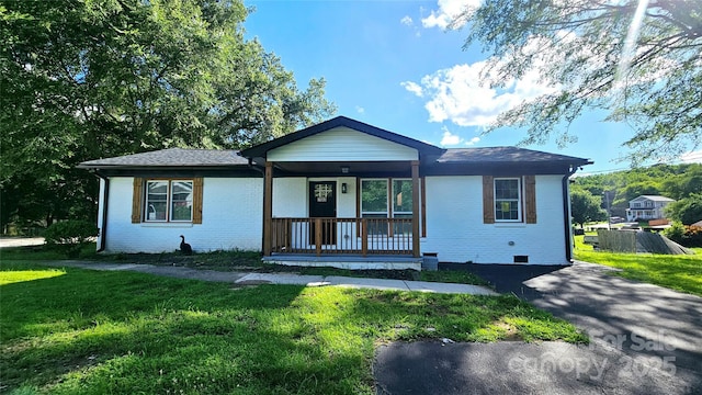 703 Central Dr NW, Concord, NC 28027 - ranch-style home with covered porch, a front yard, and brick siding