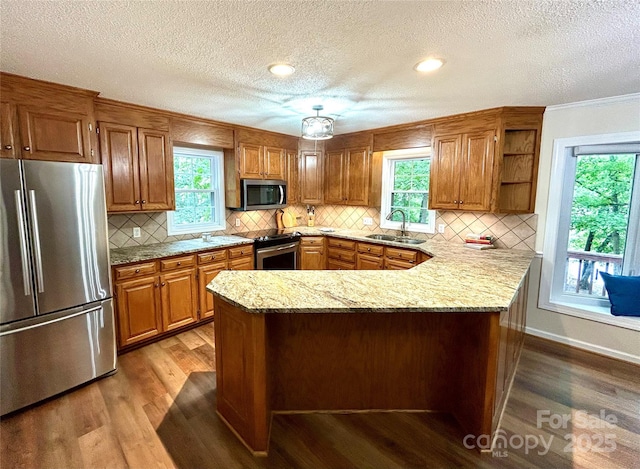 143 Uwharrie Ct Unit 1080, 1081, Mount Gilead, NC 27306 - kitchen featuring appliances with stainless steel finishes, wood finished floors, a peninsula, open shelves, and brown cabinets