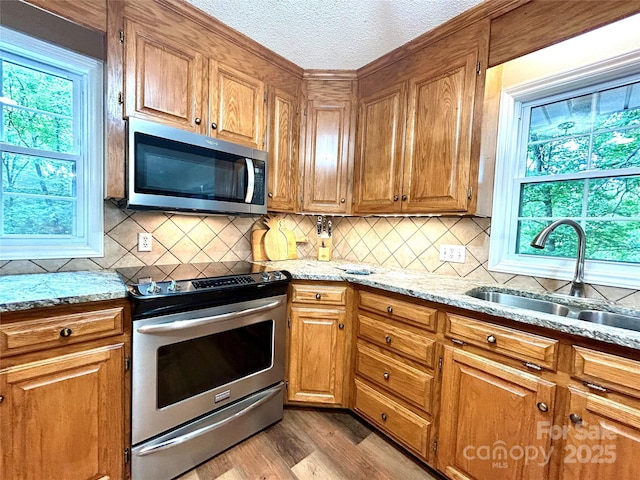 143 Uwharrie Ct Unit 1080, 1081, Mount Gilead, NC 27306 - kitchen featuring stainless steel appliances, backsplash, light stone counters, a textured ceiling, and light wood-style floors