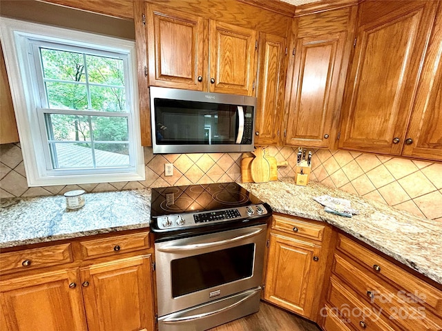 143 Uwharrie Ct Unit 1080, 1081, Mount Gilead, NC 27306 - kitchen with stainless steel appliances, brown cabinetry, and backsplash