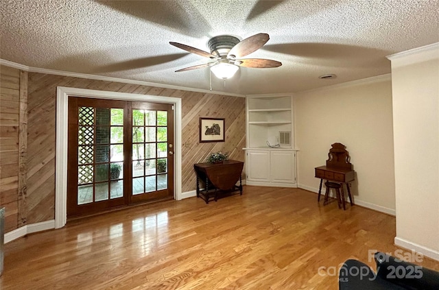 143 Uwharrie Ct Unit 1080, 1081, Mount Gilead, NC 27306 - doorway featuring crown molding, wooden walls, a textured ceiling, ceiling fan, and light wood-style flooring