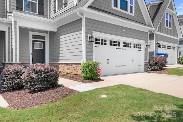 6365 Ashton Park Dr, Denver, NC 28037 - view of home's exterior featuring an attached garage, stone siding, a shingled roof, and driveway