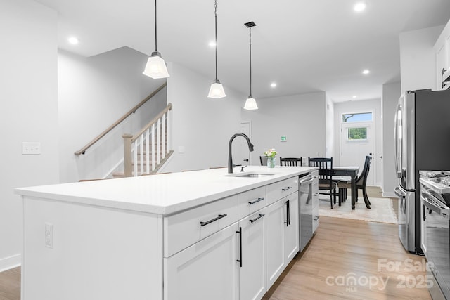 6365 Ashton Park Dr, Denver, NC 28037 - kitchen featuring stainless steel appliances, light wood-style flooring, white cabinetry, recessed lighting, and a kitchen island with sink