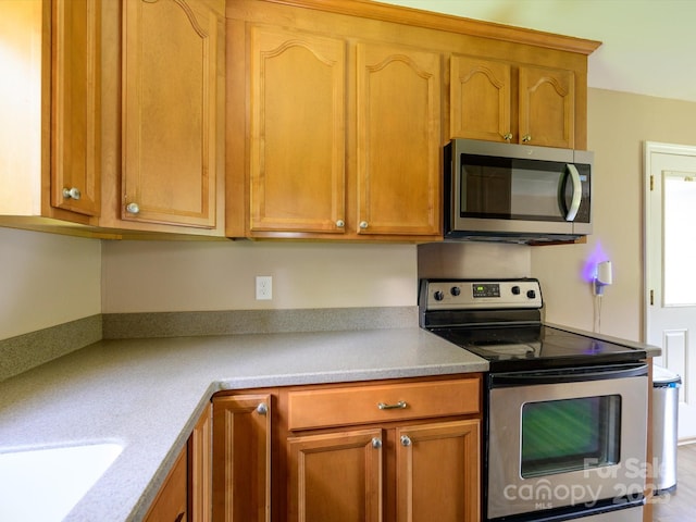 618 Springfield Dr NW, Concord, NC 28027 - kitchen featuring stainless steel appliances, light countertops, and brown cabinets
