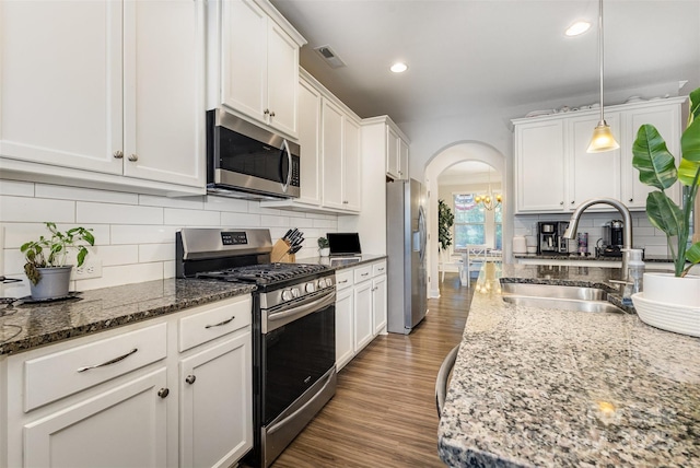 3332 Katherine Taylor Ct, Monroe, NC 28110 - kitchen with appliances with stainless steel finishes, arched walkways, white cabinetry, backsplash, and recessed lighting