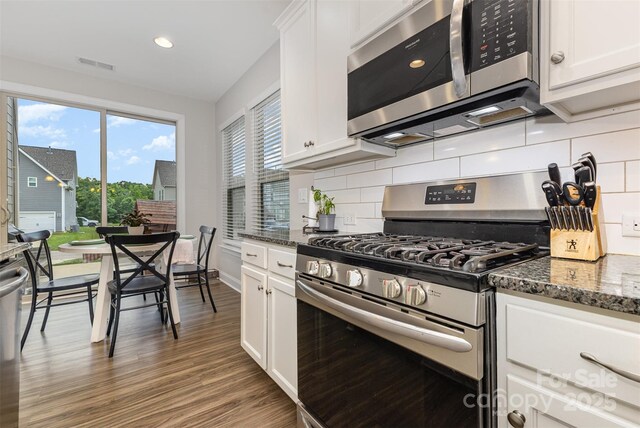 3332 Katherine Taylor Ct, Monroe, NC 28110 - kitchen featuring stainless steel appliances, backsplash, wood finished floors, white cabinets, and recessed lighting