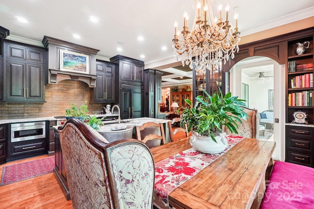229 N Church St Unit 401, Charlotte, NC 28202 - dining space featuring ornamental molding, arched walkways, light wood-style flooring, recessed lighting, and a chandelier