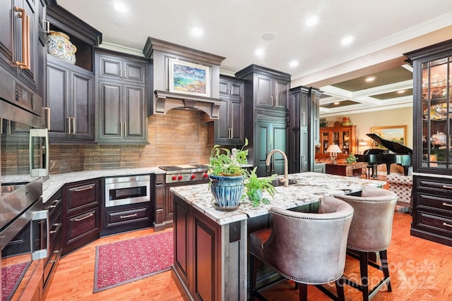 229 N Church St Unit 401, Charlotte, NC 28202 - kitchen with crown molding, backsplash, light wood finished floors, light stone countertops, and a kitchen breakfast bar
