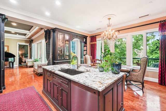 229 N Church St Unit 401, Charlotte, NC 28202 - kitchen with dishwasher, ornamental molding, pendant lighting, light stone countertops, and light wood-style floors