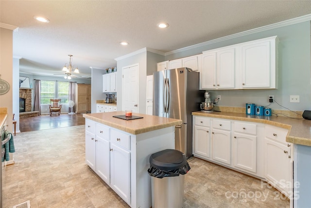 1828 Pine Hollow Pl, Hudson, NC 28638 - kitchen with freestanding refrigerator, crown molding, white cabinets, light countertops, and a kitchen island