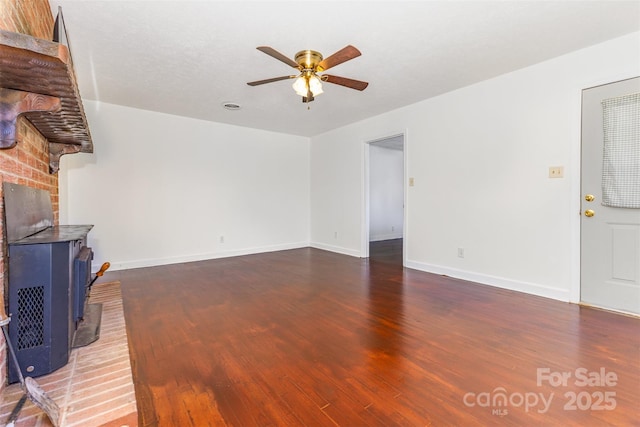 416 Pete Brittain Rd, Morganton, NC 28655 - unfurnished living room with a wood stove, ceiling fan, and dark wood finished floors
