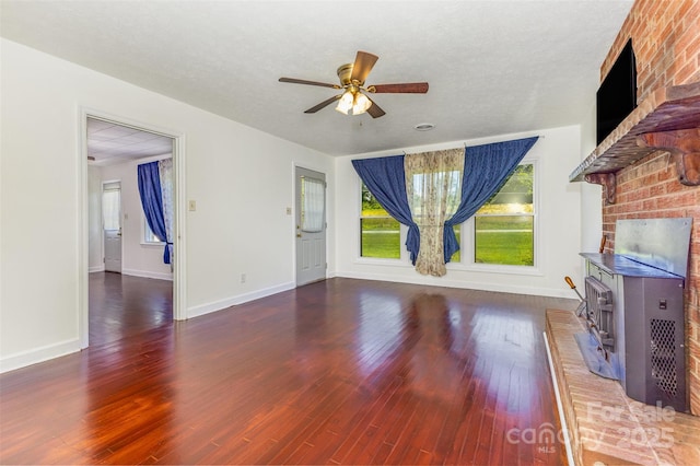 416 Pete Brittain Rd, Morganton, NC 28655 - unfurnished living room featuring plenty of natural light, ceiling fan, wood finished floors, and a wood stove