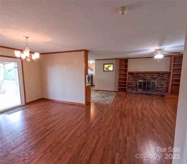 2963 Freezer Locker Rd, Hudson, NC 28638 - unfurnished living room featuring a chandelier, a ceiling fan, a brick fireplace, wood finished floors, and washer and clothes dryer