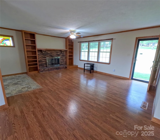 2963 Freezer Locker Rd, Hudson, NC 28638 - unfurnished living room featuring a ceiling fan, ornamental molding, wood finished floors, a fireplace, and built in shelves