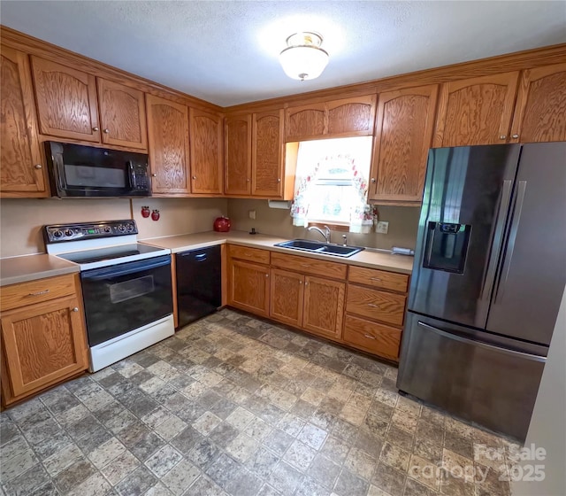 2963 Freezer Locker Rd, Hudson, NC 28638 - kitchen with black appliances, light countertops, brown cabinetry, and stone finish floors