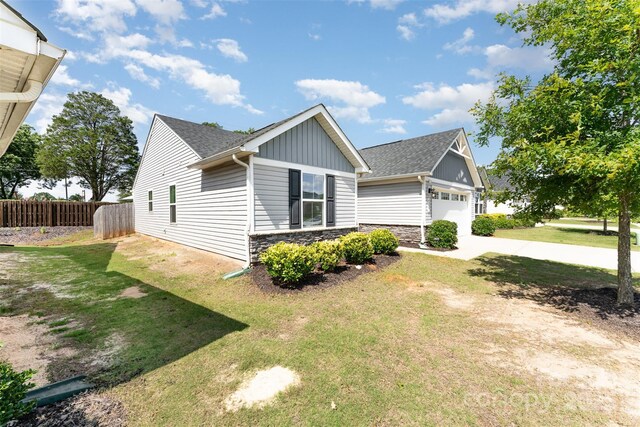 4227 Mackinnon Dr, Charlotte, NC 28214 - view of front of home with stone siding, roof with shingles, board and batten siding, and concrete driveway