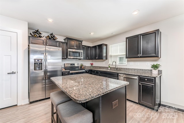 4227 Mackinnon Dr, Charlotte, NC 28214 - kitchen with appliances with stainless steel finishes, light stone counters, light wood-type flooring, a center island, and recessed lighting