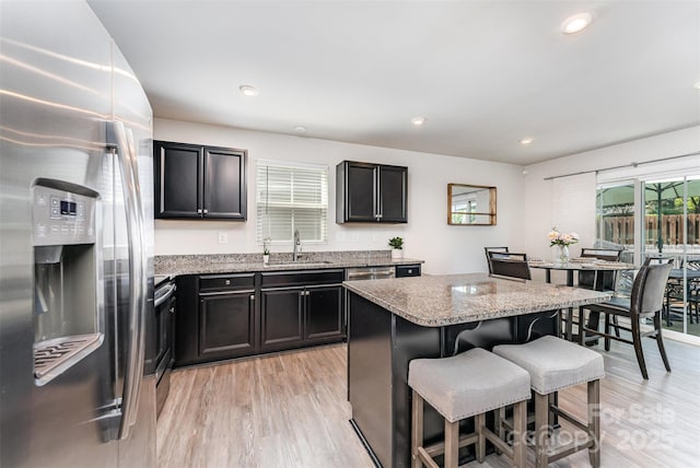 4227 Mackinnon Dr, Charlotte, NC 28214 - kitchen featuring stainless steel appliances, a breakfast bar, light wood finished floors, light stone countertops, and recessed lighting