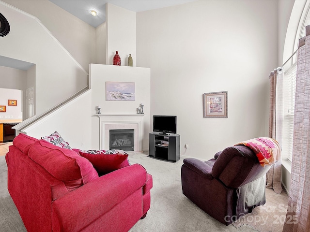 12415 Stratfield Place Cir, Pineville, NC 28134 - carpeted living area with a towering ceiling, a glass covered fireplace, and stairs