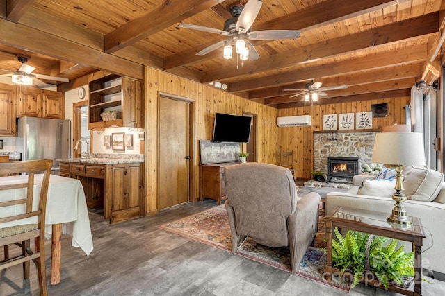 79 Creekside Ln, Spruce Pine, NC 28777 - living room with a ceiling fan, a wooden ceiling with exposed beams, wood walls, wood finished floors, and a stone fireplace