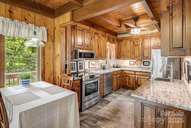 79 Creekside Ln, Spruce Pine, NC 28777 - kitchen featuring a wooden ceiling with exposed beams, stainless steel appliances, brown cabinets, wooden walls, and light stone counters