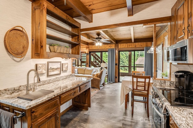 79 Creekside Ln, Spruce Pine, NC 28777 - kitchen featuring a wooden ceiling with exposed beams, wood walls, appliances with stainless steel finishes, a ceiling fan, and light stone counters