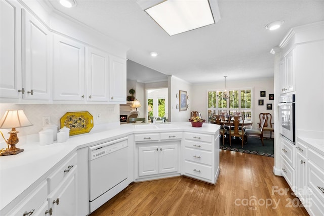 600 Queens Rd, Cherryville, NC 28021 - kitchen with dishwasher, stainless steel oven, a peninsula, light wood-type flooring, and white cabinets