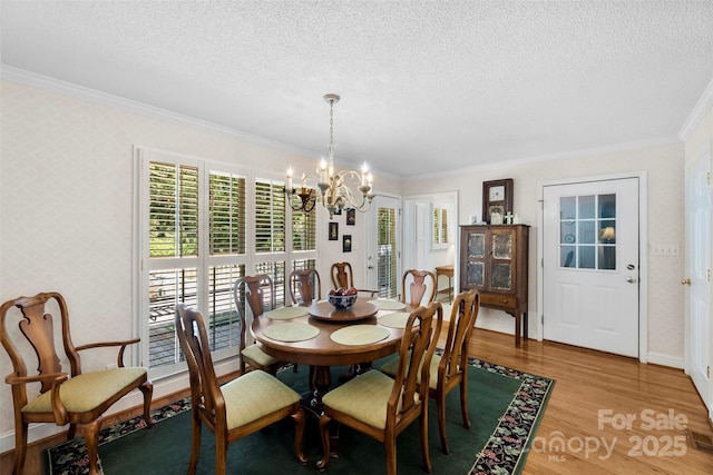 600 Queens Rd, Cherryville, NC 28021 - dining space with a chandelier, crown molding, a textured ceiling, light wood-style floors, and wallpapered walls