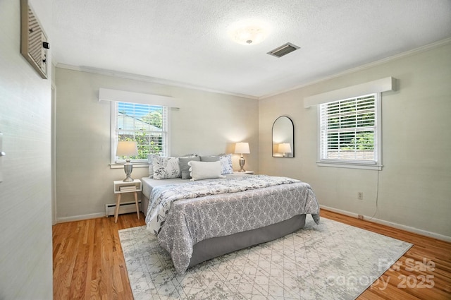900 Nance St, Kannapolis, NC 28083 - bedroom with a baseboard radiator, crown molding, light wood-style flooring, and a textured ceiling