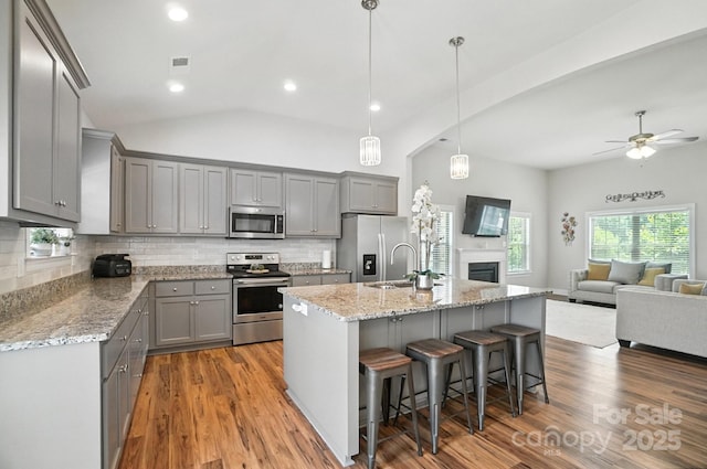 3256 Fairmead Dr, Concord, NC 28025 - kitchen featuring stainless steel appliances, gray cabinets, wood finished floors, lofted ceiling, and recessed lighting