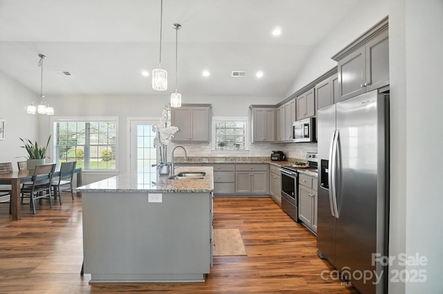3256 Fairmead Dr, Concord, NC 28025 - kitchen with appliances with stainless steel finishes, gray cabinetry, lofted ceiling, an island with sink, and light stone countertops
