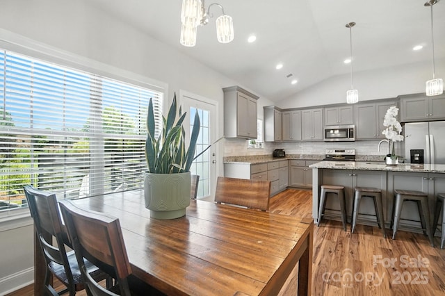 3256 Fairmead Dr, Concord, NC 28025 - dining space featuring vaulted ceiling, healthy amount of natural light, wood finished floors, recessed lighting, and a chandelier