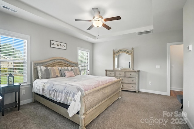 3256 Fairmead Dr, Concord, NC 28025 - carpeted bedroom featuring a tray ceiling, multiple windows, and ceiling fan
