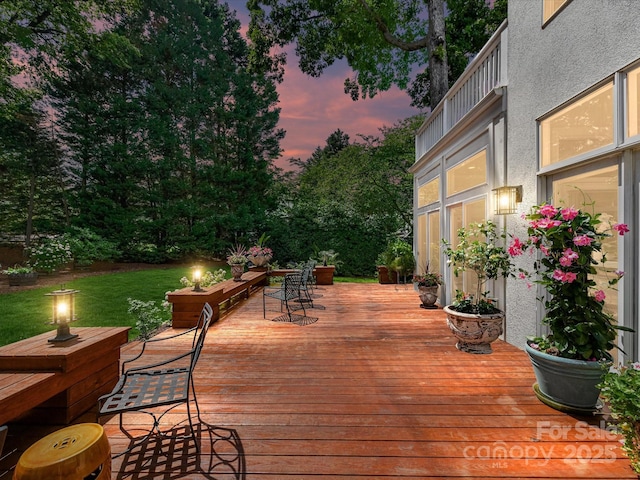 19205 Hidden Cove Ln, Cornelius, NC 28031 - deck at dusk featuring a lawn and outdoor dining space