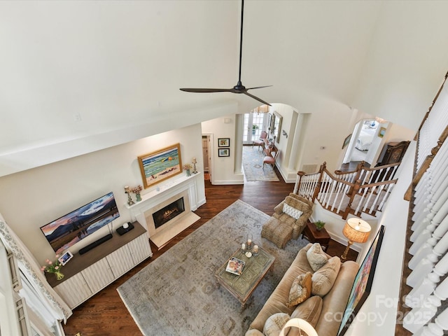 19205 Hidden Cove Ln, Cornelius, NC 28031 - living area featuring dark wood-type flooring, a ceiling fan, stairway, and a fireplace with flush hearth