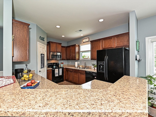 3009 Canopy Dr, Indian Trail, NC 28079 - kitchen with black appliances, healthy amount of natural light, recessed lighting, a peninsula, and light stone countertops