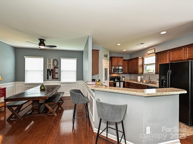 3009 Canopy Dr, Indian Trail, NC 28079 - kitchen featuring black appliances, a wainscoted wall, ceiling fan, dark wood-style floors, and a peninsula