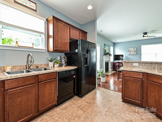 3009 Canopy Dr, Indian Trail, NC 28079 - kitchen with black appliances, healthy amount of natural light, a fireplace with flush hearth, a ceiling fan, and recessed lighting