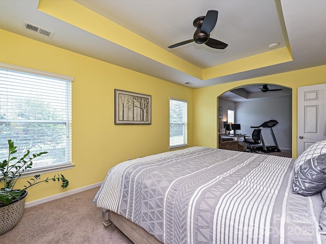 3009 Canopy Dr, Indian Trail, NC 28079 - carpeted bedroom with a tray ceiling, a ceiling fan, and arched walkways